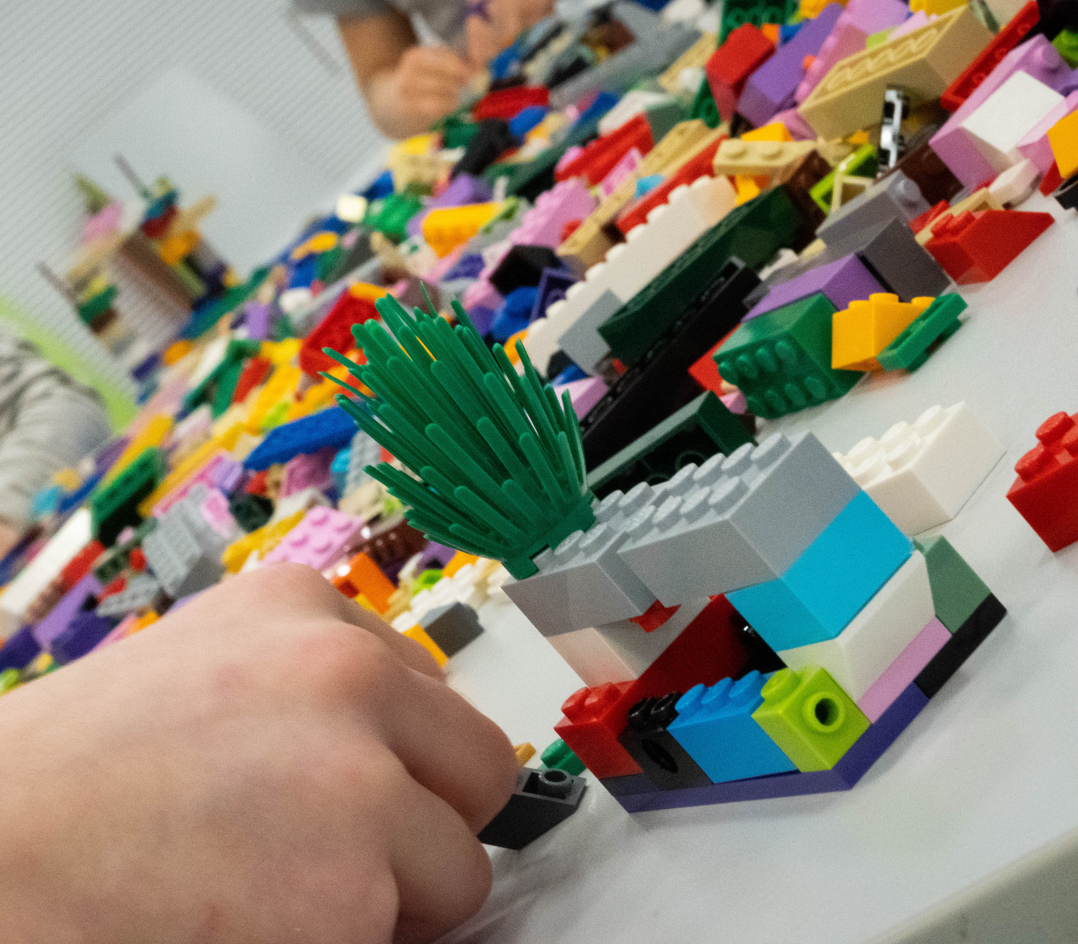 Uczestnicy warsztatów budujący modele z klocków LEGO